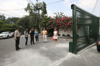 Un grupo de residentes, acompañados por la Policía, muestra los portones que se han colocado en el malecón.