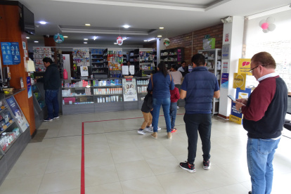 Un grupo de usuarios espera su turno en una farmacia de la empresa municipal Farmasol.