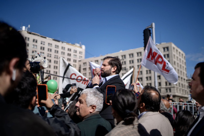 Gabriel Boric, mientras habla a manifestantes que protestan a favor del derecho a la vivienda digna, hoy, a las afueras del palacio La Moneda, en Santiago (Chile)
