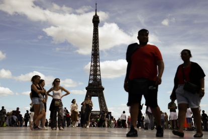 Paris (France), 12/08/2023.- People stand near the Eiffel tower at Place Trocadero in Paris, France, 12 August 2023. According to Societe D"exploitation De La Tour Eiffel (SETE) "lit.: Eiffel Tower Operating Company", three floors of Eiffel Tower were briefly evacuated after security threat announced. (Francia) EFE/EPA/MOHAMMED BADRA