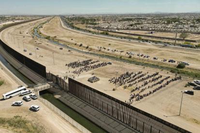 Fotografía de archivo muestra a cientos de migrantes mientras esperan junto al muro fronterizo en El Paso, Texas (EE.UU). EFE/ Jonathan Fernández