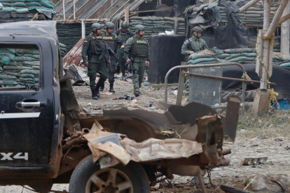 Policías vigilan de cerca al carro bomba que explotó en Timba, Cauca, Colombia.