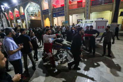 Un herido es evacuado -la noche del 13 de agosto- después de un ataque con armas de fuego contra el mausoleo chií Shah Cheragh.