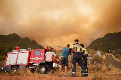 Un retén de bomberos en la zona de Los Márgenes, en el pueblo de Igueste de Candelaria, donde avanza el incendio forestal que afecta a los municipios de Arafo y Candelaria, en la isla de Tenerife. EFE/Ramón de la Rocha