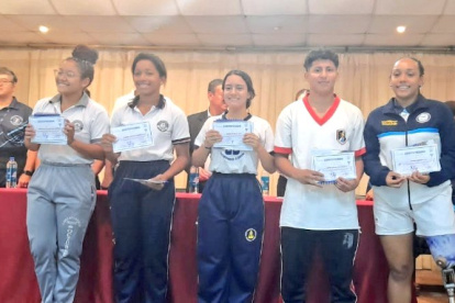 Un grupo de jóvenes muestran los diplomas que recibieron.