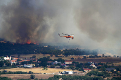 Un helicóptero contra incendios sobrevuela la zona afectada por un incendio forestal cerca del puerto de Alexandroupolis, Grecia, este domingo 20 de agosto.