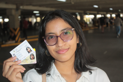 Liz Suárez, de 17 años, quien sufragó por primera vez, muestra su cédula y certificado de votación.