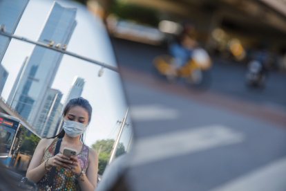 Una mujer con mascarilla camina por una calle de Pekín, China, estel 21 de agosto de 2023. La subcepa EG.5 de la variante Omicron se ha convertido en la fuente más importante de infecciones por COVID-19 en China.