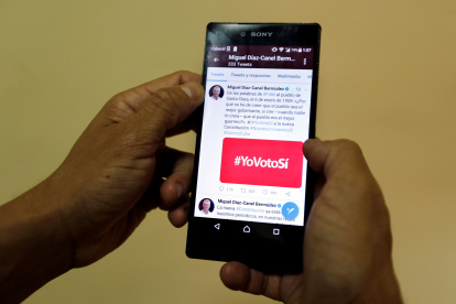 Tendencias. Una persona muestra la pantalla de su móvil con un hashtag relativo a un tema político.