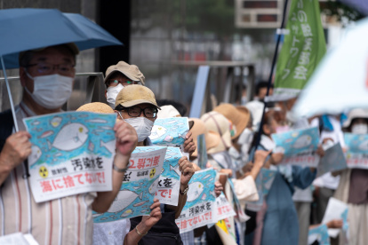 Manifestantes sostienen carteles contra el vertido al océano Pacífico de agua tratada que procede de la planta nuclear de Fukushida, este 24 de agosto en Tokio.