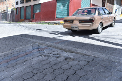 Daños. Los adoquines rotos han producido  baches que deben esquivar para evitar daños.