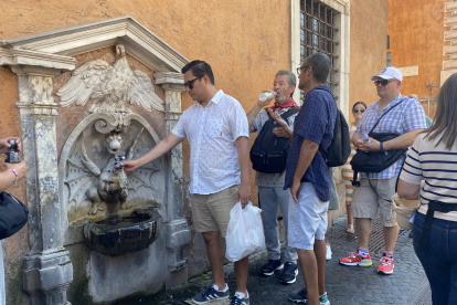 Turistas beben en una fuente, este viernes en Roma.