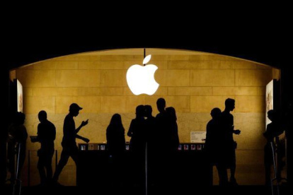 Referencial. Una imagen que muestra el logo de Apple y a clientes.