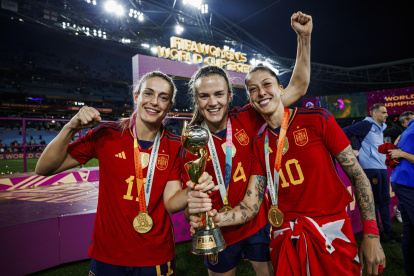 Las jugadoras de la selección española de fútbol femenino Alexia Putellas (i), Irene Parades (c) y Jenni Hermoso posan con el trofeo del Campeonato del Mundo.