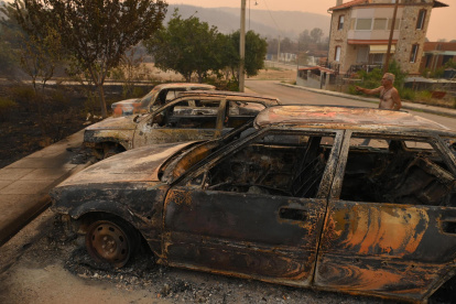 Un hombre señala coches quemados durante un incendio forestal, en la aldea de Palagia, Alejandrópolis, Tracia, en el norte de Grecia.