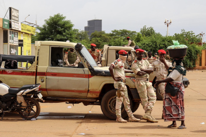 Soldados hablan con una mujer en los exteriores de un estadio en Niamey, Niger.