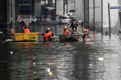 Los equipos de respuesta a emergencias utilizan balsas para ayudar a transportar a los residentes a lo largo de una carretera inundada en Filipinas.
