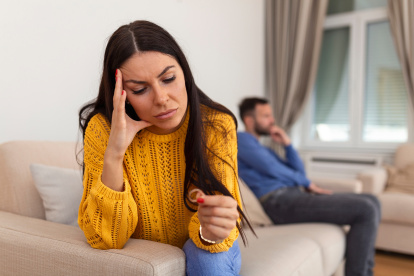 Stressed wife holding her wedding ring worried about breakup or divorce, avoid talking with husband after fight, anxious couple ignore each other. Frustrated sad wife taking off the wedding ring