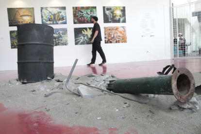 El autor. Narcis Alispahic camina entre algunos de sus cuadros y una instalación que son parte de su muestra.