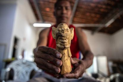 Oficio. El maestro Sandro esculpe una pequeña ‘carranca’, en su taller de artesanías ‘Maestro Quincas’.
