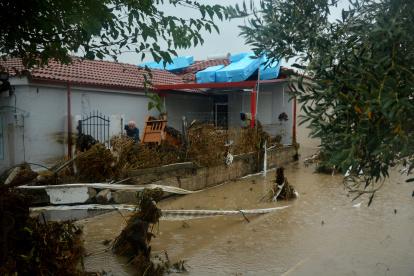 un hombre intenta limpiar el barro del patio de su casa en la aldea de Nees Karies, cerca de Larissa, Tesalia, Grecia central, 06 de septiembre de 2023.