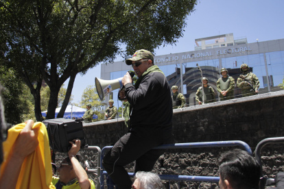 Afuera del CNE, en Quito, decenas de personas pedían la renuncia de los vocales electorales.