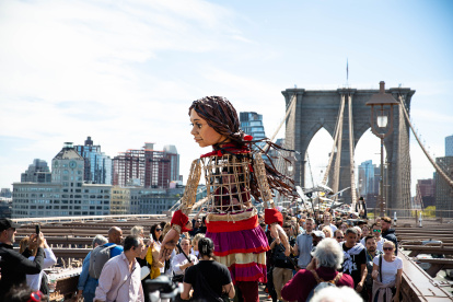 Amal, es una marioneta de 3,6 metros de altura que representa a una niña siria refugiada de 10 años que dejó su país en busca de su madre que emigró hacia el Reino Unido.