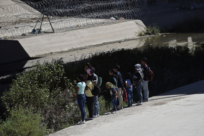 Un grupo de migrantes camina a un costado del río Bravo, frontera natural entre México y EE.UU., hoy, en Ciudad Juárez, Chihuahua (México).