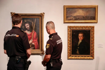 Agentes contemplan tres de las cinco obras de arte falsas
