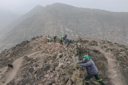 Operarios trabajan en el desmonte de un muro que divide los distritos de La Molina y Villa del Triunfo.