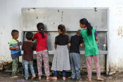 Niños llenan botellas con agua en una aldea en la franja de Gaza el pasado 28 de agosto