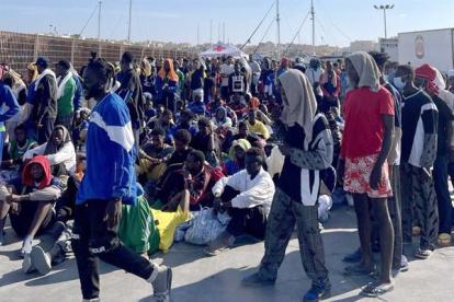 Un grupo de migrantes espera en la isla de Lampedusa mientras las autoridades italianas se preparan para trasladar a las personas tras los recién llegados, Italia, 13 de septiembre de 2023