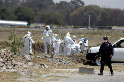 Fotografía de archivo de peritos forenses que realizan el levantamiento de cuerpos hallado