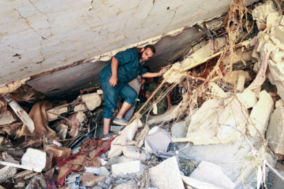 Varias personas buscan supervivientes entre los escombros de un edificio que se derrumbó durante las inundaciones tras el paso de la tormenta mediterránea Daniel por la ciudad oriental libia de Derna, el 14 de septiembre de 2023