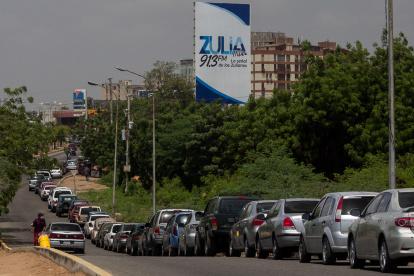 AME4465. MARACAIBO (VENEZUELA), 04/06/2020.- Un grupo de carros y motos hacen fila para cargar combustible en una estación de gasolina, este jueves en Maracaibo (Venezuela). Venezuela registra este jueves largas colas e incidentes en las gasolineras, en las que ha vuelto a fallar el suministro después de tres días de un repostaje masivo con el combustible que el Gobierno compró a Irán, ante la escasez que vivió el país caribeño los últimos meses. La reapertura de las gasolineras trajo consigo la salida a la calle de los ciudadanos, confinados desde mediados de marzo por la cuarentena por COVID-19 y por la escasez de combustible, que obligó a los venezolanos a dejar sus vehículos estacionados. EFE/ Henry Chirinos VENEZUELA CRISIS