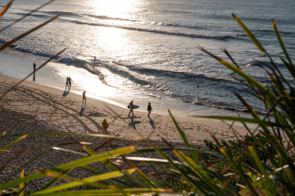 Pistas. Varios bañistas aparecen en una playa de Australia en medio de una ola de calor.