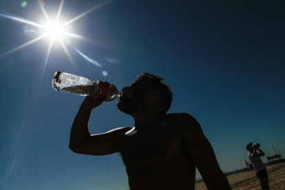 Un hombre bebe agua durante el descanso de una actividad física este 19 de septiembre de 2023 en la playa de Copacabana, en Río de Janeiro.