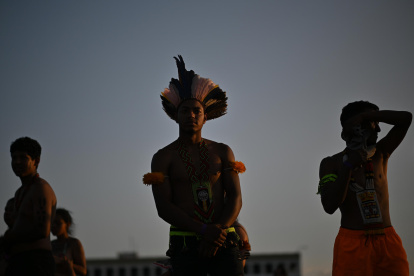 Indígenas observan este miércoles la transmisión del juicio sobre el marco temporal en una pantalla gigante instalada frente al Supremo Tribunal Federal, en Brasilia.