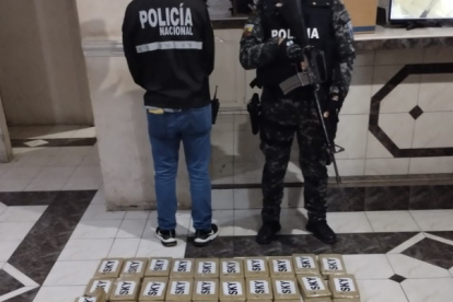 Agentes policiales junto a la droga incautada.
