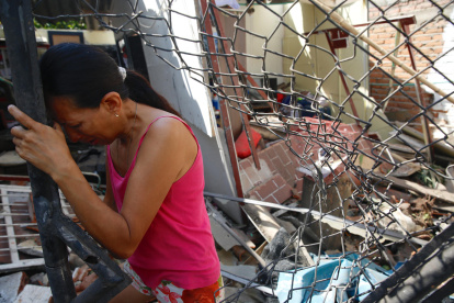 Mónica Grajales llora en la puerta de su vivienda destruida por un carro bomba, en el municipio de Jamundí.