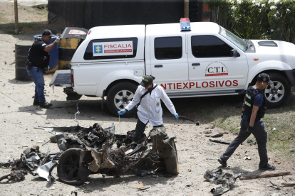 Técnicos antiexplosivos inspeccionan un carro bomba, activado contra una subestación de policía hoy, en el corregimiento Potrerito, del municipio de Jamundí, Valle del Cauca (Colombia).
