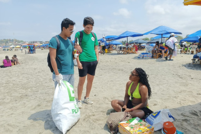 Los estudiantes dialogan con los turistas sobre la importancia de mantener limpias las playas.