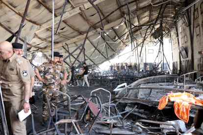 Los policías inspeccionan la escena la mañana después de que estallara un incendio en un salón de bodas en la ciudad de Hamdaniya, provincia de Nínive, al norte de Irak, el 27 de septiembre de 2023.