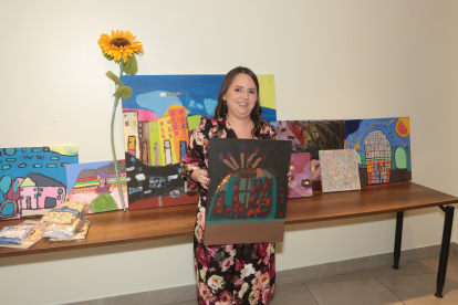 Karyna junto a los cuadros de su autoría que también fueron expuestos.