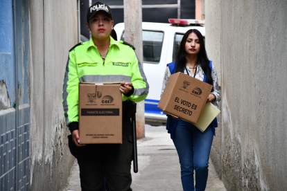 Asistencia. Funcionaria electoral lleva la urna a una casa.