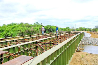 Prevención. Un par de obreros se ocupan en el proceso de la instalación de uno de los puentes bailey.