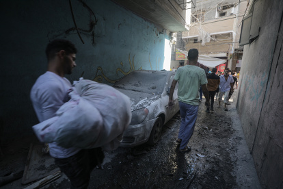 Un cuerpo es cargado del lugar del ataque aéreo de Israel en el campo de refugiados Shati en Gaza