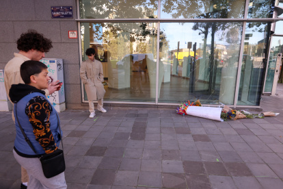 Un grupo de personas observa el ramo de flores colocados en el sitio donde dos personas fueron atacadas este lunes 16 de octubre de 2023 en Bruselas.