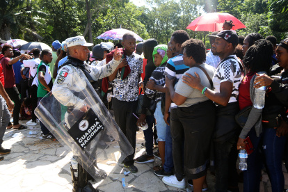 Personal de la Guardia Nacional resguardan a migrantes hoy, durante una revisión de documentos, en el Ecoparque de Tapachula, en el estado de Chiapas (México).