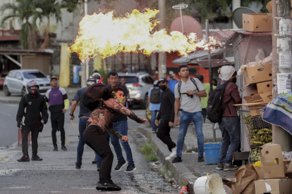 Manifestantes se enfrentan a la policía durante una protesta hoy, en las afueras de la Asamblea Nacional de Ciudad de Panamá (Panamá).